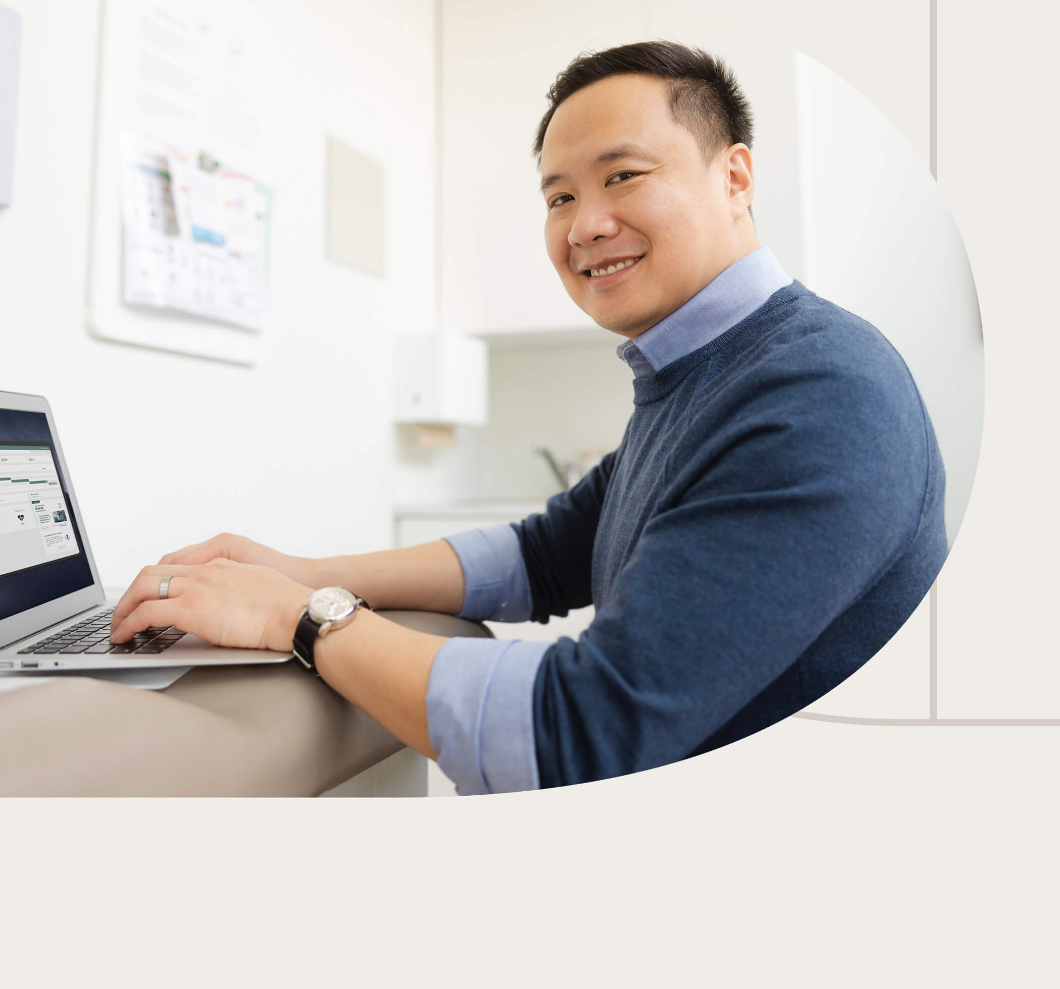 Male doctor types in his computer.