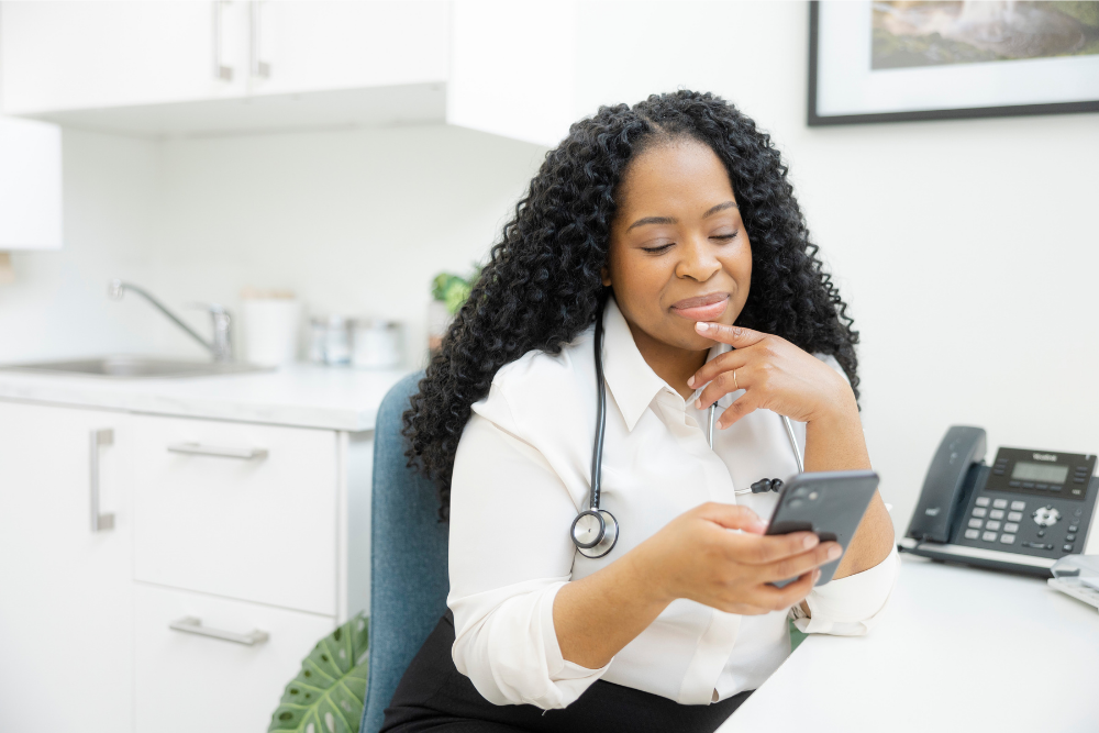 A female doctor uses her mobile phone.